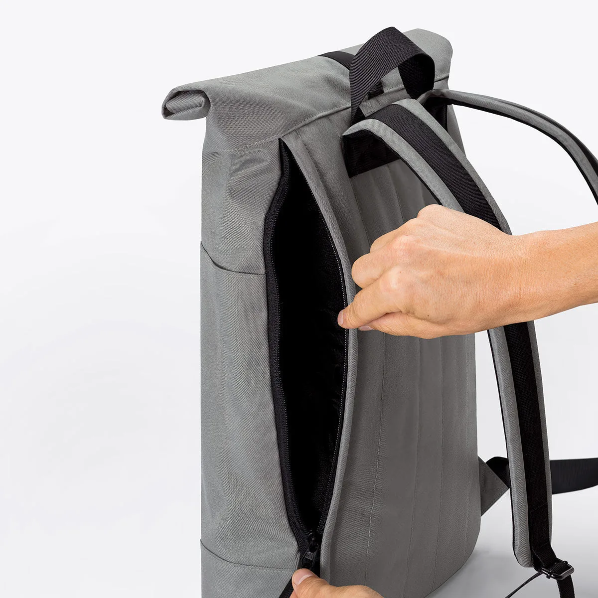 Main ouvrant l'accès latéral zippé au compartiment principal du sac Ucon Acrobatics Hajo Medium Stealth gris