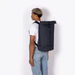 Man wearing the Ucon Acrobatics Hajo Pro backpack in dark navy, side view showing its size on the back