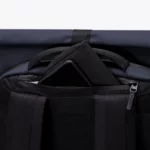 Pocket at the top of the back panel of the Ucon Acrobatics Hajo Pro backpack in dark navy holding a phone and wallet