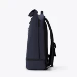 Left side view of the Ucon Acrobatics Hajo Pro backpack in dark navy with rolled top and separate bottom compartment