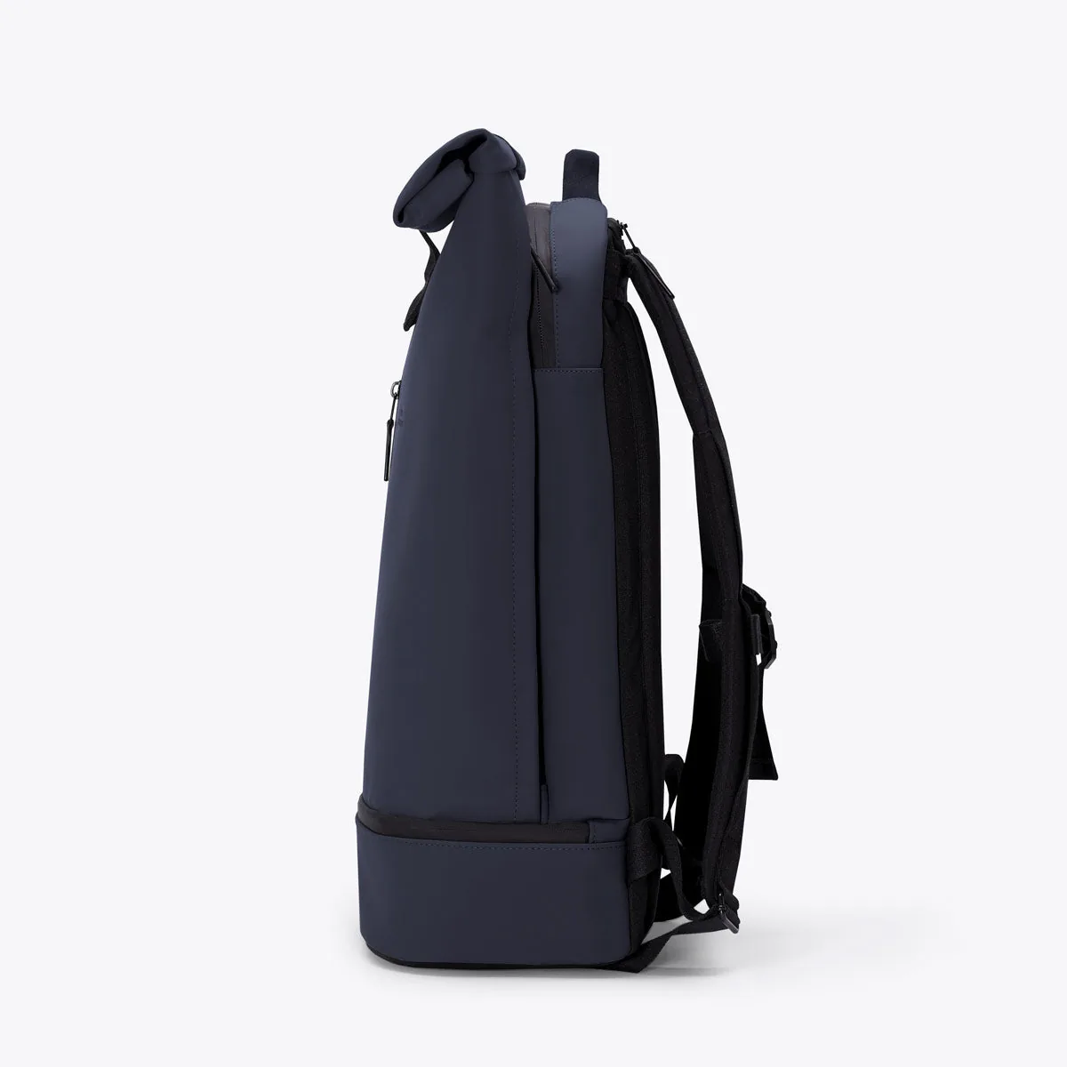 Left side view of the Ucon Acrobatics Hajo Pro backpack in dark navy with rolled top and separate bottom compartment