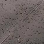 Water droplets on the water-repellent PU material of the Ucon Acrobatics Hajo Pro in dark grey, close-up of a seam