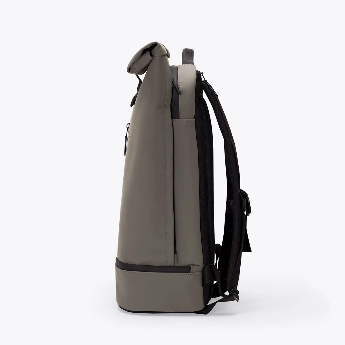 Left side view of the Ucon Acrobatics Hajo Pro backpack in dark grey with rolled top and separate bottom compartment