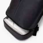 Open bottom compartment of the Ucon Acrobatics Hajo Pro backpack in black holding a sneaker, apart from the main bag