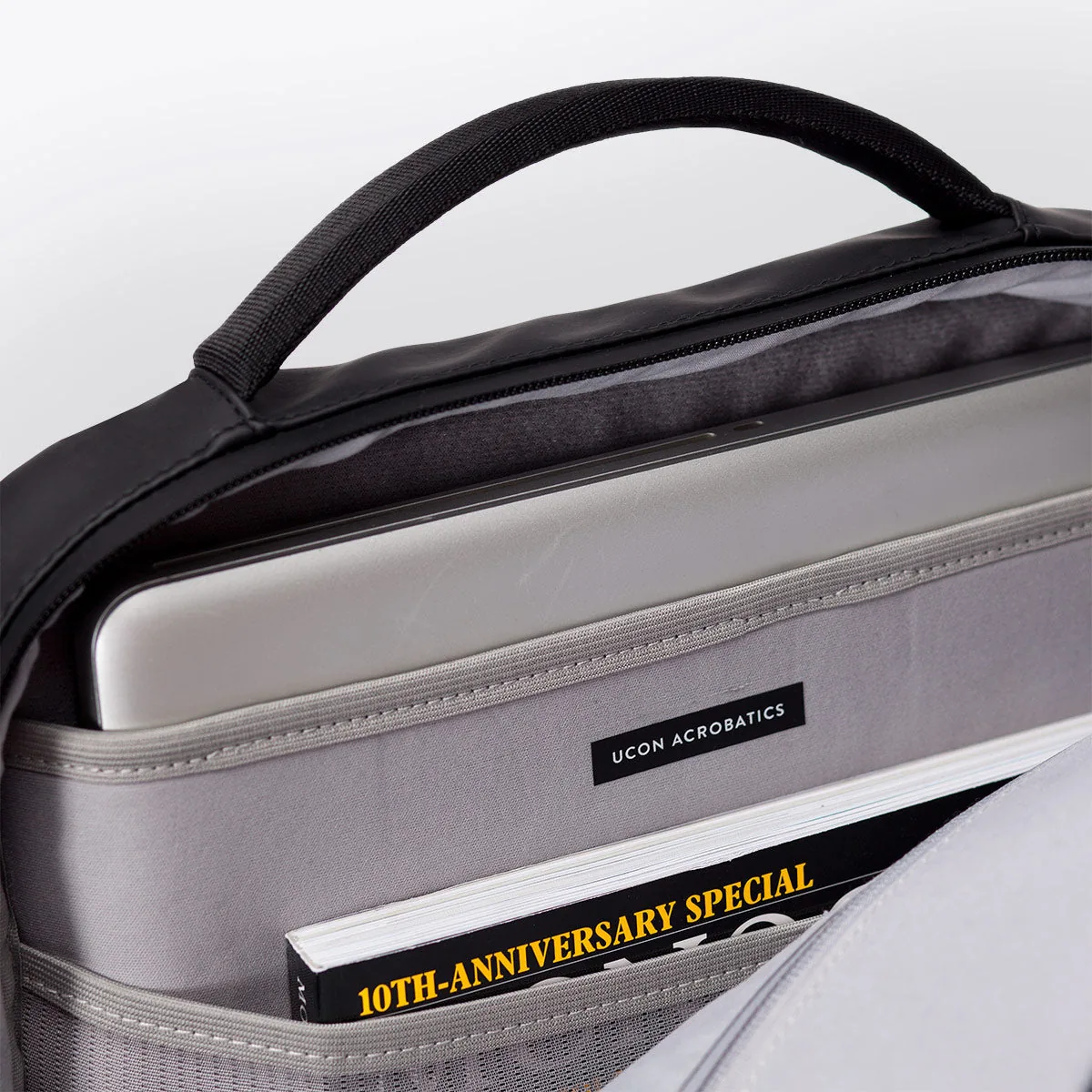 Inside the main compartment of the Ucon Acrobatics Hajo Pro backpack in black with laptop sleeve and brand label