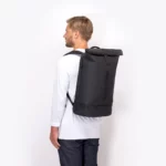 Man wearing the Ucon Acrobatics Hajo Pro backpack in black, side view showing its size on the back