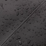 Water droplets on the water-repellent PU material of the Ucon Acrobatics Hajo Pro in black, close-up of a seam
