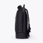 Left side view of the Ucon Acrobatics Hajo Pro backpack in black with rolled top and separate bottom compartment
