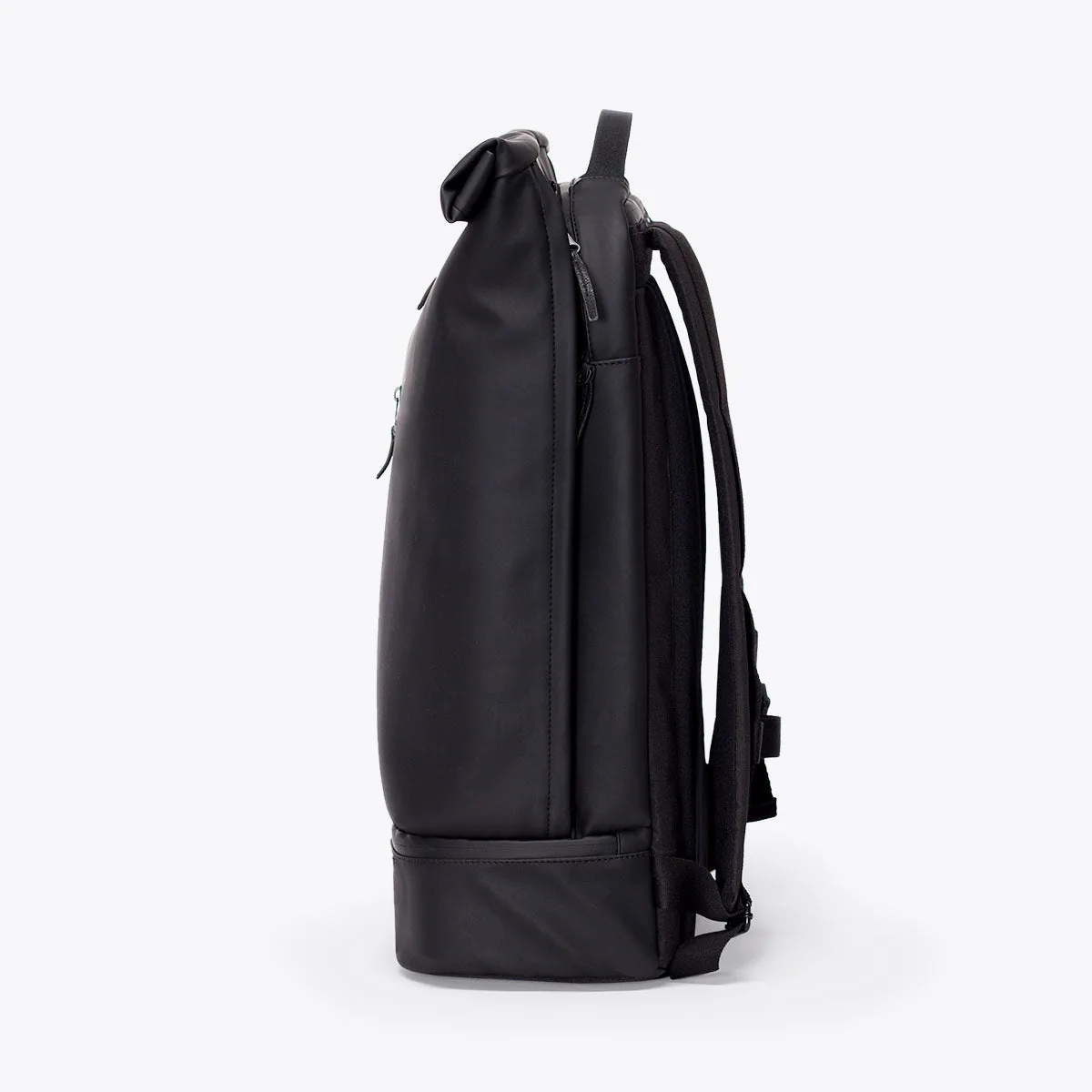 Left side view of the Ucon Acrobatics Hajo Pro backpack in black with rolled top and separate bottom compartment